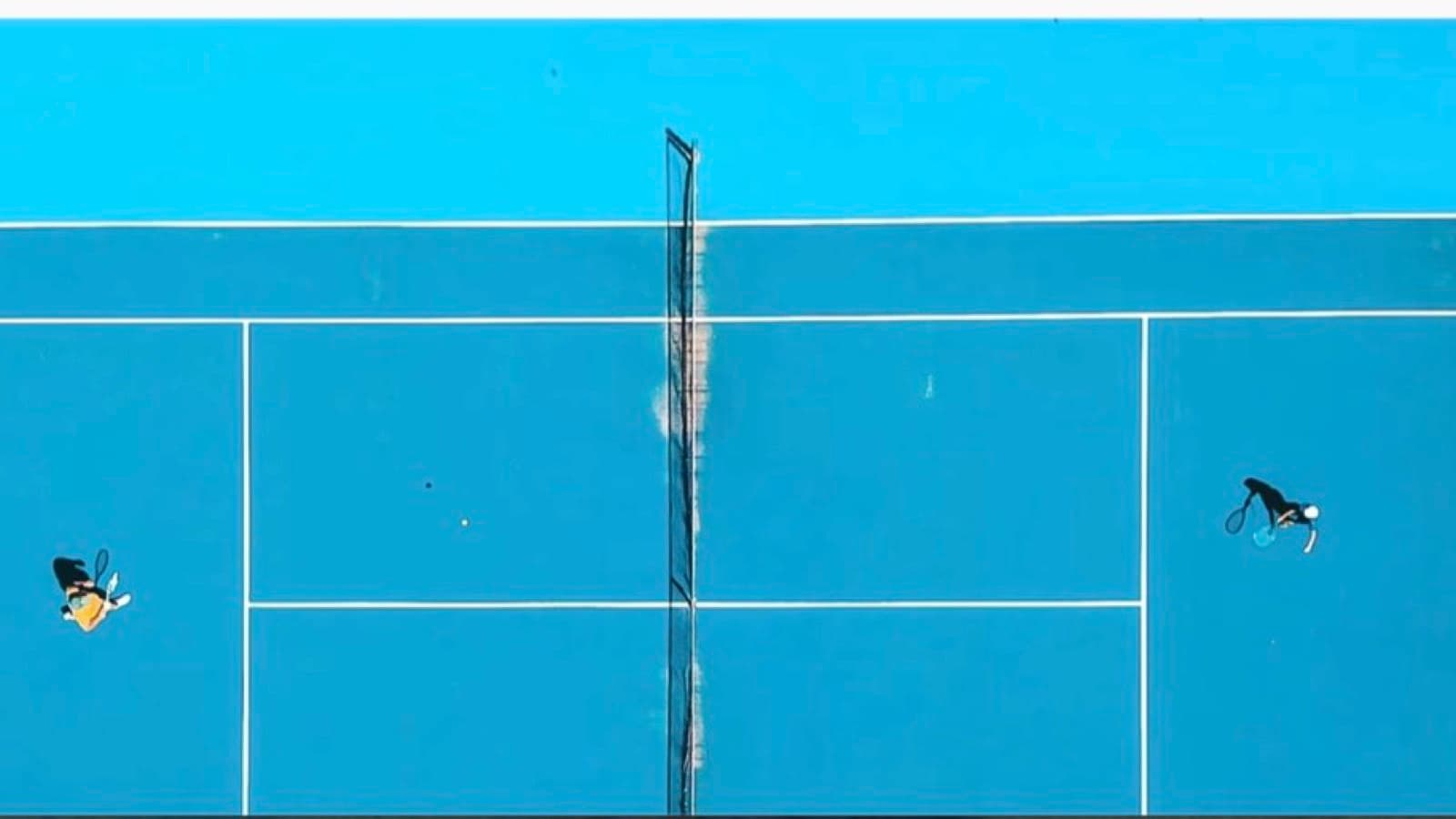 An aerial view of a blue tennis court